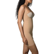 Woman wearing a nude full bodysuit with adjustable straps.