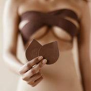 Brown pasties held by a model, perfect for discreet coverage.